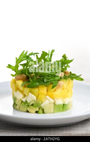 Avocat, mangue fraîche, mozzarella et salade de roquette assaisonnée de noix Banque D'Images