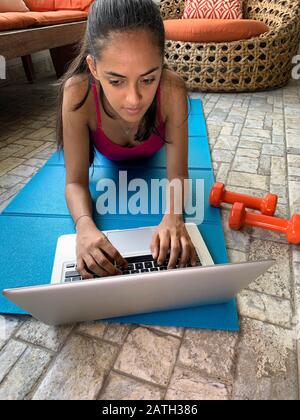 Fille latine exerçant à la maison avec un ordinateur portable, Panama, Amérique centrale Banque D'Images