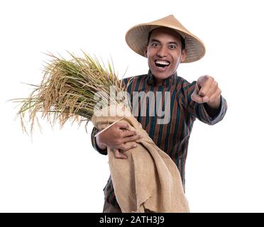 agriculteur asiatique pointant son doigt vers l'appareil photo tout en portant un tissu traditionnel Banque D'Images