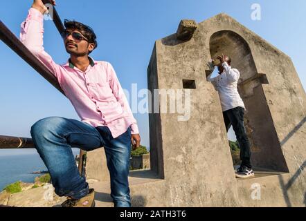 Un portrait de rue grand angle d'un homme prenant une photo de son ami sur les remparts du fort De L'Udi. Banque D'Images