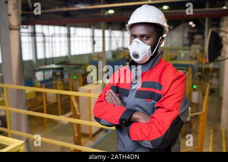 Portrait d'un jeune homme africain confiant dans un respirateur et un casque de protection travaillant dans l'industrie toxique Banque D'Images