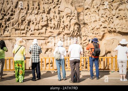 Touristes regardant un bas-relief de granit du huitième siècle connu sous le nom de la pénitence d'Arjuna à Mamallapuram près de Chenai. D'une série de photos de voyage à Sout Banque D'Images