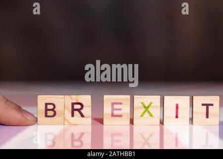 La main ajoute le mot exit avec les lettres B et R, donnant le mot Brexit Banque D'Images