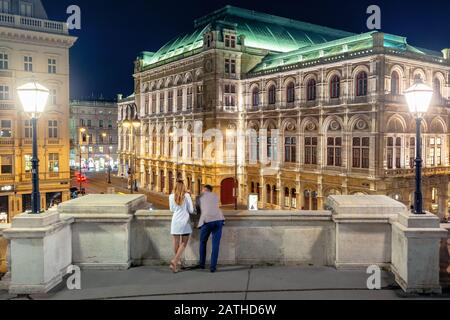 couple sur le balcon d'albertina profiter de la vue. beau paysage urbain de l'opéra d'état de vienne en autriche la nuit. valentines jour datant concept Banque D'Images