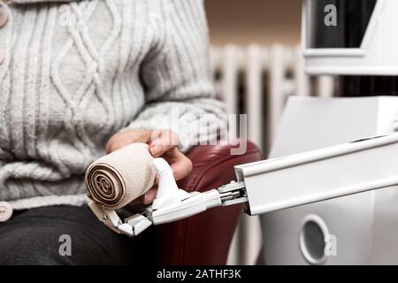 le robot autonome de soignant est muni d'un bandage élastique, le donnant à une femme adulte âgée dans son salon, concept de vie assistée ambiante Banque D'Images