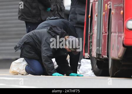Les autorités judiciaires font des recherches sous un bus sur les lieux à la suite de l'attaque terroriste de Streatham High Road, dans le sud de Londres par Sudesh Amman, 20 ans, qui a été abattu par la police armée à la suite de ce que la police a déclaré comme un incident terroriste. Banque D'Images