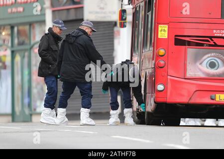 Les autorités judiciaires font des recherches sous un bus sur les lieux à la suite de l'attaque terroriste de Streatham High Road, dans le sud de Londres par Sudesh Amman, 20 ans, qui a été abattu par la police armée à la suite de ce que la police a déclaré comme un incident terroriste. Banque D'Images