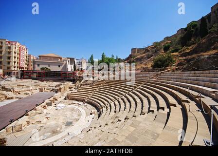 Vue sur l'amphithéâtre romain dans le centre-ville surplombant le château à droite, Malaga, Malaga Province, Andalousie, Espagne. Banque D'Images