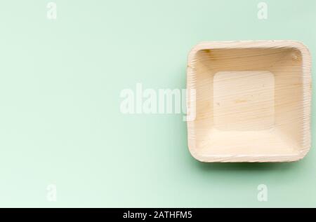 Tasse et plaques faites de feuilles de palmier sur un fond vert Banque D'Images