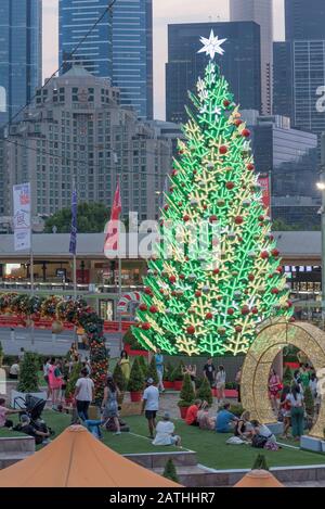 Décembre 2019 : décorations de début de soirée et de Noël avec un grand arbre de Noël éclairé sur la place de la Fédération (Fed) dans le centre de Melbourne, en Australie Banque D'Images