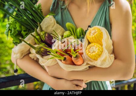 Ensemble de légumes frais dans un sac réutilisable entre les mains d'une jeune femme. Concept zéro déchet Banque D'Images