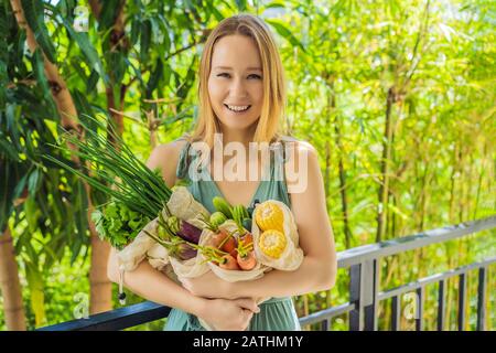 Ensemble de légumes frais dans un sac réutilisable entre les mains d'une jeune femme. Concept zéro déchet Banque D'Images