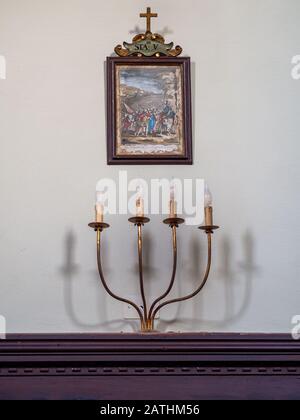 BORGHERI, TOSCANE, ITALIE - 26 janvier 2020: À l'intérieur de l'église de Santi Jacopo e Cristoforo à Bolgheri. 5ème station de la croix avec des bougies. Banque D'Images