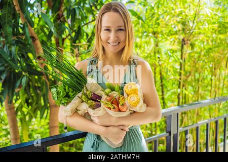 Ensemble de légumes frais dans un sac réutilisable entre les mains d'une jeune femme. Concept zéro déchet Banque D'Images