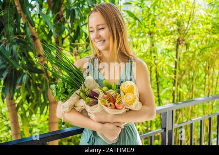 Ensemble de légumes frais dans un sac réutilisable entre les mains d'une jeune femme. Concept zéro déchet Banque D'Images