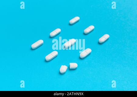 Pilules ovales blanches revêtues de film sur fond bleu Banque D'Images