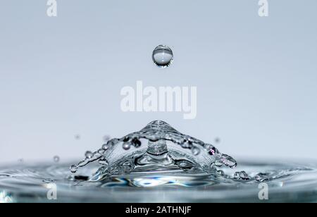 Les gouttes d'eau forment des sculptures transparentes fascinantes sous forme de champignons ou de parapluie lorsqu'elles tombent dans l'eau, des gouttes et des éclaboussures se ferment Banque D'Images