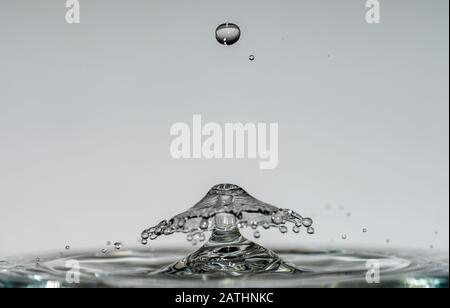 Les gouttes d'eau forment des sculptures transparentes fascinantes sous forme de champignons ou de parapluie lorsqu'elles tombent dans l'eau, des gouttes et des éclaboussures se ferment Banque D'Images