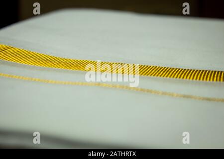 Vue rapprochée du dhoti avec bordure filetée en or. Dhoti est une robe traditionnelle de l'inde du sud que les hommes portent pendant les festivals, les mariages. Banque D'Images