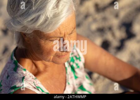 Vieille femme se reposant sur la plage Banque D'Images