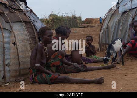 Omorate, Ethiopie - Nov 2018 : femmes et enfants assis à l'extérieur de leurs maisons dans le village. Vallée de l'Omo Banque D'Images