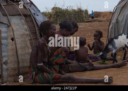 Omorate, Ethiopie - Nov 2018 : femmes et enfants assis à l'extérieur de leurs maisons dans le village. Vallée de l'Omo Banque D'Images