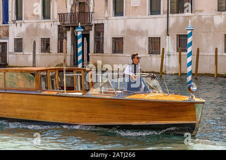 Un bateau-taxi de Venise naviguant le long d'un canal, Venise, Italie Banque D'Images