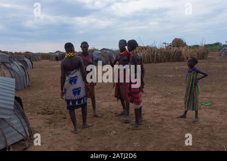 Omorate, Ethiopie - Nov 2018: Les jeunes hommes et femmes portent des vêtements traditionnels tribales et des colliers qui parlent les uns avec les autres. Vallée de l'Omo Banque D'Images