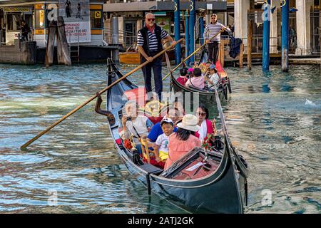 Les gondoliers qui prennent un groupe de touristes chinois pour une balade en gondole au-delà de La Ca' d'Oro un palais gothique, le long Du Grand Canal, Venise, Italie Banque D'Images