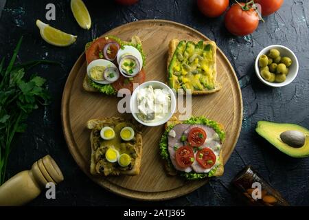 Combinaison avec différents types de sandwichs et de souce sur la planche en bois: Avec champignons, avec avocat Banque D'Images