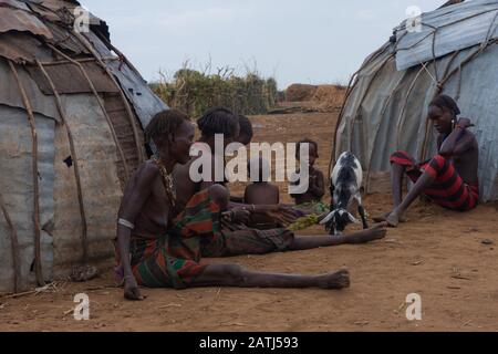 Omorate, Ethiopie - Nov 2018 : femmes et enfants assis à l'extérieur de leurs maisons dans le village. Vallée de l'Omo Banque D'Images