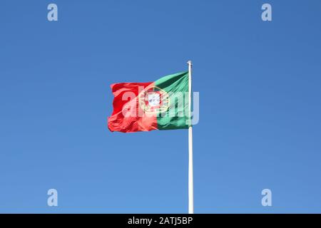 Le drapeau du Portugal agitant dans le vent sur le ciel bleu Banque D'Images