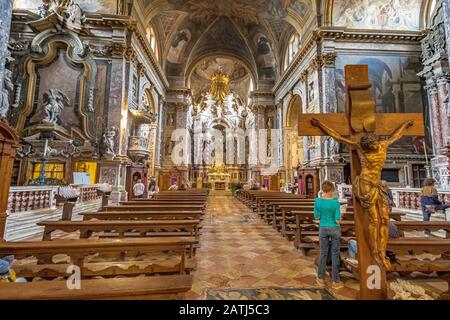 Une femme se tient près d'un crucifix à l'intérieur de l'église Santa Maria di Nazareth, Venise, Italie Banque D'Images