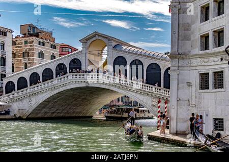 Une télécabine fait le chemin le long Du Grand Canal surveillé par une foule de personnes sur Le pont du Rialto, Venise, Italie Banque D'Images