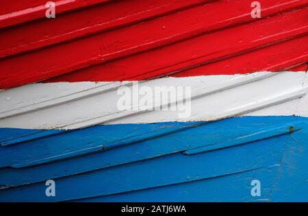 coque peinte colorée sur l'ancien bateau de pêche, puits-près-de-la-mer, nord norfolk, angleterre Banque D'Images