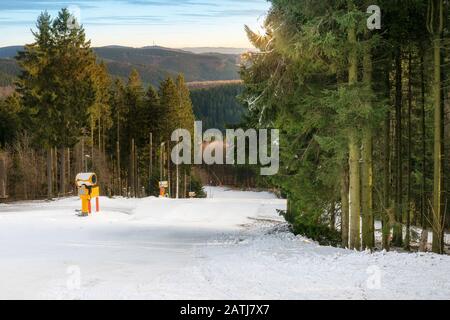 Belle piste de ski dans la forêt. Des canons à neige ont fourni une couche de neige. La journée d'hiver avec un beau temps vous invite à des sports d'hiver. Banque D'Images