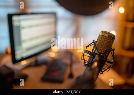 Microphone condensateur gros plan doré dans le studio d'enregistrement créant l'effet sonore pour le créateur de contenu de Vlog ou Blogger freelance Banque D'Images