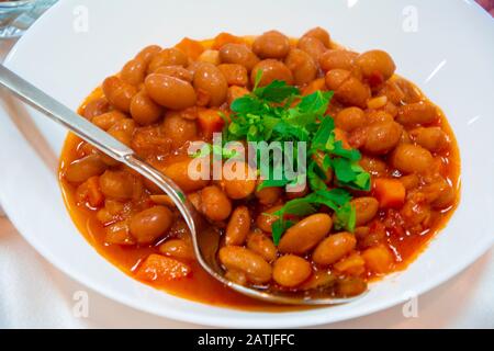 Haricots rouges dans la sauce tomate gros plan sur la plaque blanche Banque D'Images