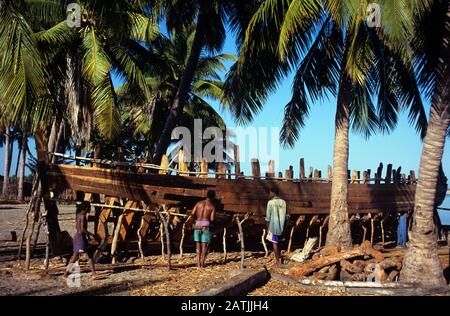 Artisans malgaches ou constructeurs de bateaux bâtissant un dhow traditionnel en bois à Belo sur Mer près de Morondavo dans l'ouest de Madagascar Banque D'Images