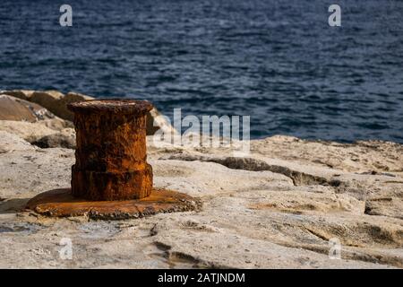 Un vieux balard rouillé au bord de mer à Malte, peu profond du champ. Banque D'Images
