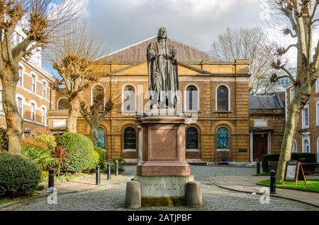 Une statue de John Wesley, fondateur de l'église méthodiste, se tient devant la chapelle de Wesley sur City Road, Londres, Royaume-Uni Banque D'Images