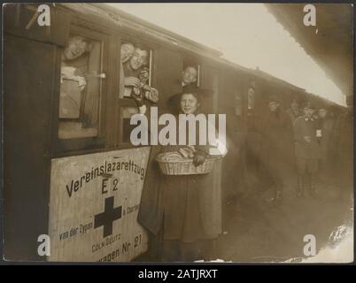 Description: Arrivée de l'anglais à Roozendaal. Annotation: Wagon de chemin de fer, Vereinslazaretzug la firme Zijpen & Charlier de Cologne-Deutz; l'employé de la Croix-Rouge néerlandaise partage du pain. Rire des soldats britanniques qui traînaient hors des fenêtres. Date : (1914-1918) lieu : Pays-Bas, Roosendaal mots clés : citoyens, première guerre mondiale, militaire, chemin de fer Banque D'Images