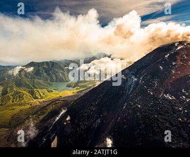 Vue aérienne des volcans de Bougainville, Papouasie-Nouvelle-Guinée. Derrière le volcan actif de Bagana émerge la formation remplie d'eau du lac Billy Mitchell Banque D'Images