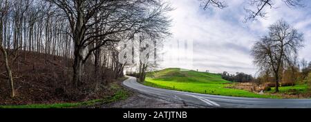 Route sinueuse dans une scène de panorama forestier dans un paysage rural avec arbres et champs Banque D'Images
