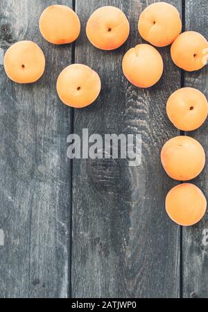 Des abricots jaunes mûrs se trouvent sur une table en bois. Gros plan. Banque D'Images