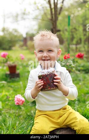 Un Petit Garcon Heureux Mange Du Gateau De Paques Dans Le Jardin De Printemps A L