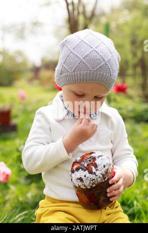 Un Petit Garcon Heureux Mange Du Gateau De Paques Dans Le Jardin De Printemps A L