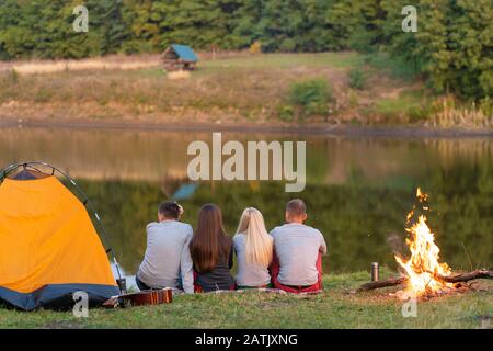 Un groupe d'amis est enjoying view, camping avec joie sur Riverside. Banque D'Images