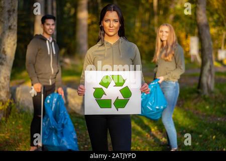 Une femme volontaire confiante portant un étiquette de symbole de recyclage Banque D'Images