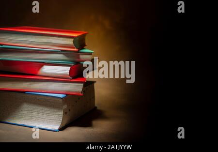 Pile de livres de couverture rigide sur fond brun, espace pour le texte à droite Banque D'Images